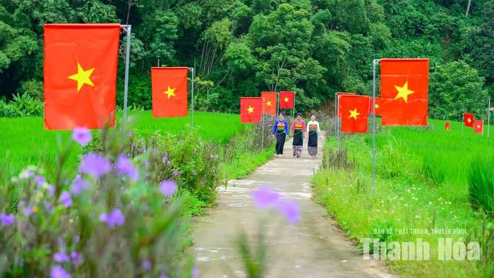 Từ rất sớm, chính quyền địa phương và người dân đã chuẩn bị cờ, cắm ngay ngắn dọc tuyến đường dẫn vào bản, tạo nên không khí trang trọng.