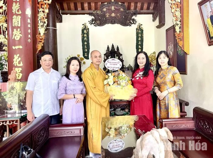 Giám đốc Sở Dân tộc và Tôn giáo Vũ Thị Hương tặng hoa chúc mừng và Đại đức Thích Nguyên Phong, Phó Ban Trị sự GHPG tỉnh, trụ trì chùa Phạm Thông.