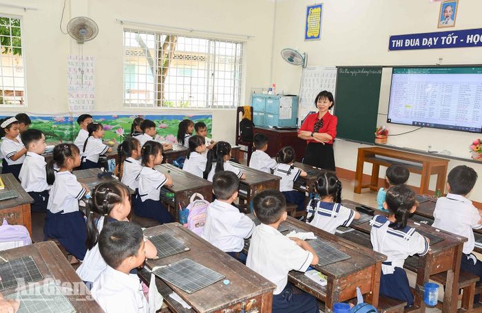 Cô Nguyễn Thị Thảo, giáo viên chủ nhiệm lớp 1/4, Trường Tiểu học Kiên Lương 1 hướng dẫn học sinh làm quen với môi trường học tập mới trong ngày đầu tiên đến lớp. Ảnh: VĂN PHỤNG