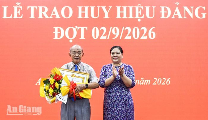 Phó Bí thư chuyên trách Đảng ủy UBND tỉnh An Giang Bùi Thị Hiền trao Huy hiệu 40 năm tuổi Đảng cho đảng viên.