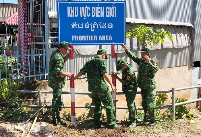 Cán bộ, chiến sĩ Đồn Biên phòng Phú Hữu cắm biển báo biên giới trong khu dân cư biên giới.