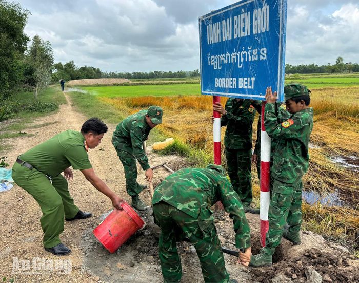 Cán bộ, chiến sĩ Đồn Biên phòng cửa khẩu Giang Thành cùng các lực lượng tiến hành thi công cắm biển báo trong khu vực biên giới.