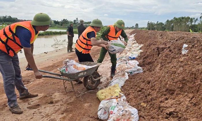  Lực lượng chức năng hỗ trợ xã Bố Hạ gia cố bờ bao ngăn nước tràn vào khu dân cư. 