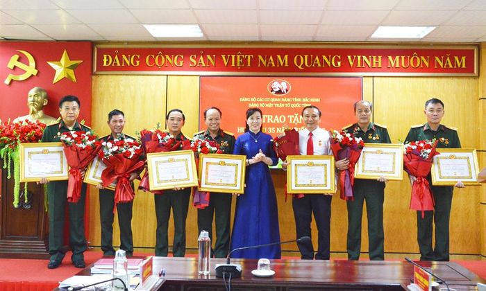  Đồng chí Nguyễn Thị Hà trao Huy hiệu 35 năm tuổi Đảng cho các đảng viên.  