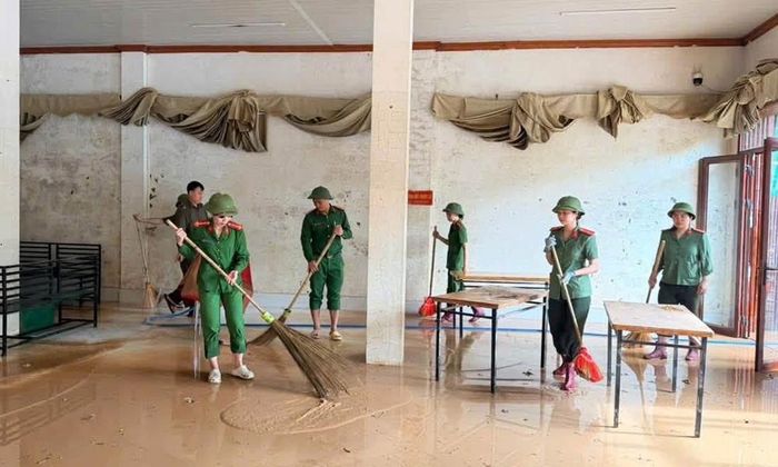 Cán bộ công an phường Chũ hỗ trợ các hộ dân dọn dẹp bùn đất.  
