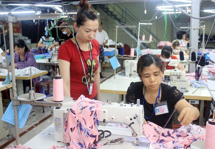  Chị Giáp Thị Huế (người ngồi) được hỗ trợ, tạo việc làm ổn định tại doanh nghiệp. 