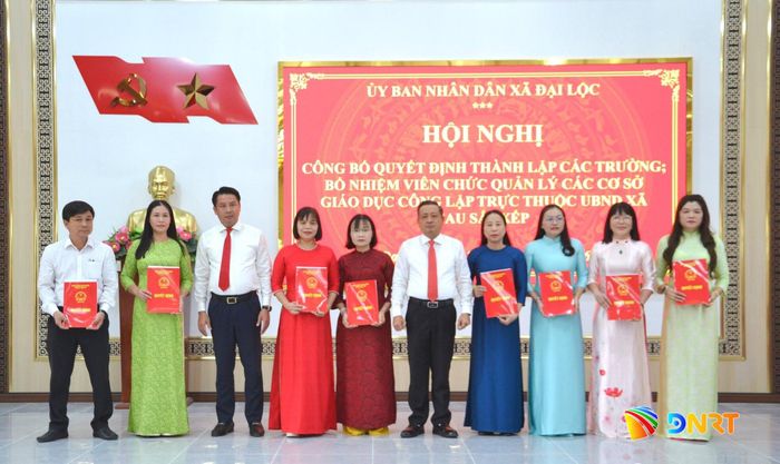 Bí thư Đảng ủy xã Đại Lộc Nguyễn Hảo (thứ 5, bên phải sang), Chủ tịch UBND xã Lê Đỗ Tuấn Khương (thứ 3, bên trái sang) trao quyết định thành lập 8 trường. Ảnh: CÔNG TÚ