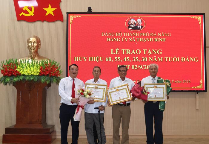 Đồng chí Trần Ngọc Tài - Bí thư Đảng ủy xã Thạnh Bình (bên trái, ngoài cùng) trao Huy hiệu Đảng đợt 2/9 cho các đảng viên. Ảnh: HƯNG HUYNH