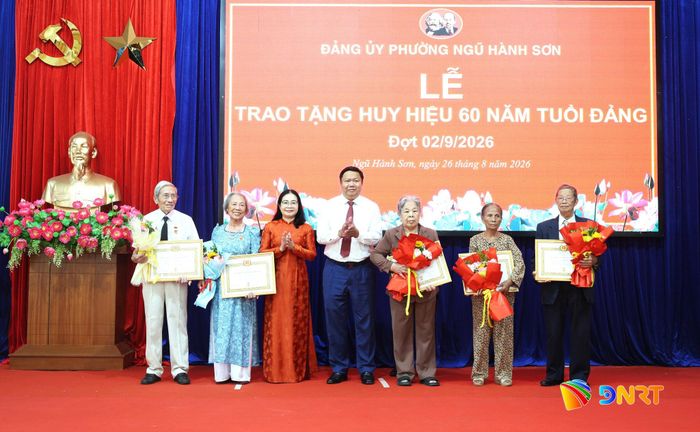 Phó Trưởng ban Thường trực Ban Nội chính Thành ủy Trần Công Thành (giữa) trao Huy hiệu 60 năm tuổi Đảng cho đảng viên. Ảnh: NGỌC HÀ