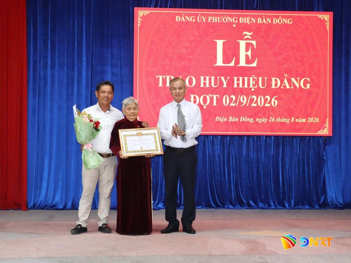 Phó Chủ nhiệm Thường trực Ủy ban Kiểm tra Thành ủy Nguyễn Đức Tiến (bên phải) trao Huy hiệu 70 năm tuổi Đảng cho đảng viên Võ Thị Tiền. Ảnh: QUỐC TUẤN