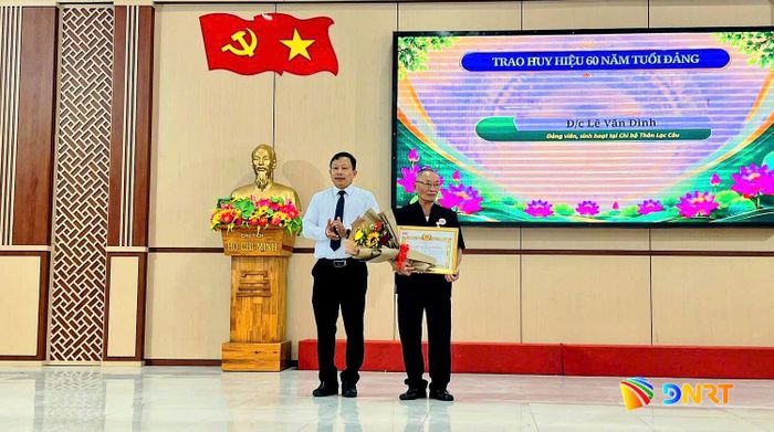 Trưởng ban Tổ chức Thành ủy Đoàn Duy Tân trao Huy hiệu 60 năm tuổi Đảng cho đảng viên Lê Văn Đình. Ảnh: HỒNG NĂM