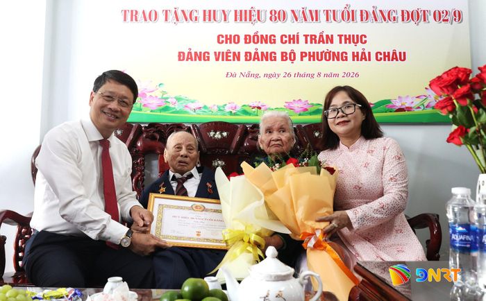 Phó Bí thư Thành ủy Ngô Xuân Thắng (bên trái) trao Huy hiệu 80 năm tuổi Đảng cho đảng viên Trần Thục. Ảnh: NGỌC HÀ