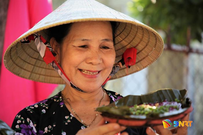 Một nữ nghệ nhân ẩm thực hào hứng giới thiệu món bánh đúc đặc sản của địa phương. Ảnh: ALĂNG NGƯỚC