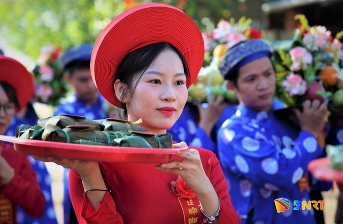 Đại diện thế hệ trẻ xã Chiên Đàn mặc áo dài, khăn đóng truyền thống cùng dâng mâm lễ ngày hội. Ảnh: ALĂNG NGƯỚC