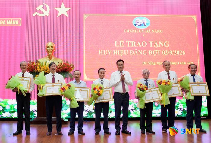 Bí thư Thành ủy Lê Ngọc Quang (thứ 4, từ phải sang) trao Huy hiệu Đảng cho các đảng viên nguyên là Ủy viên Ban Thường vụ Thành ủy Đà Nẵng, Tỉnh ủy Quảng Nam. Ảnh: T.CÔNG