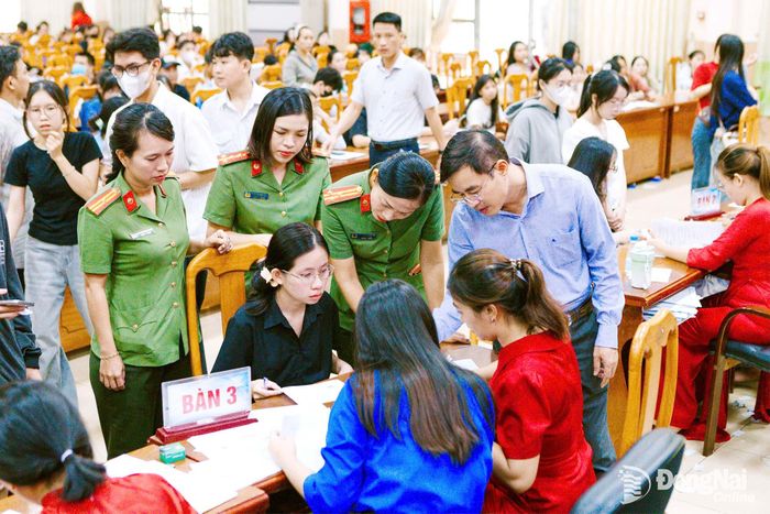 Lực lượng công an phối hợp với nhà trường hỗ trợ em Nguyễn Ngọc Minh Thư làm thủ tục nhập học. Ảnh: Vân Liên