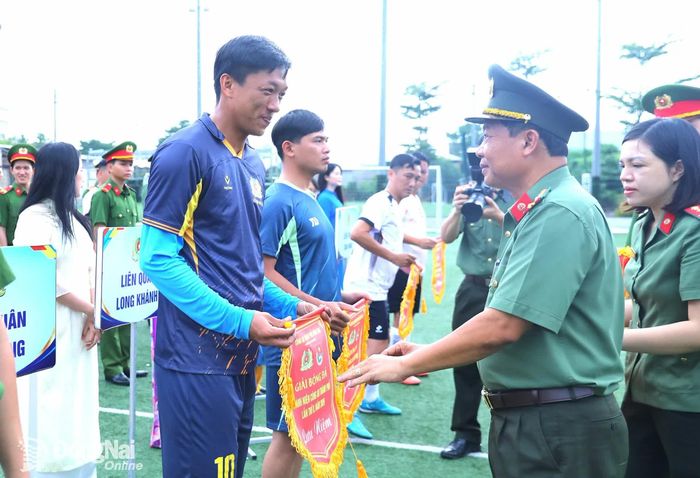Đại tá Dương Văn Mạnh, Phó Giám đốc Công an thành phố Đồng Nai tặng cờ lưu niệm cho các đội bóng tham dự giải. Ảnh: Huy Anh
