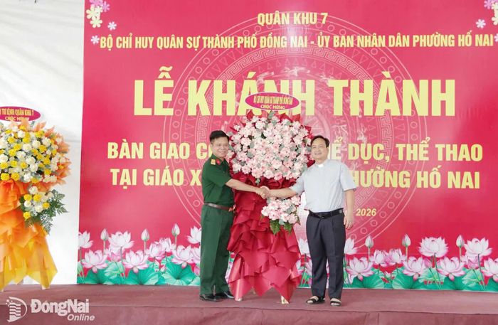 Đại tá Nguyễn Thanh Phong trao tặng hoa chúc mừng của Bộ Tư lệnh Quân khu 7 và Bộ Chỉ huy Quân sự Đồng Nai tặng giáo xứ Ngọc Đồng. Ảnh: Phan Hải
