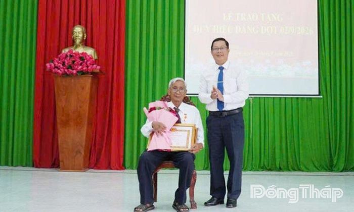 Đồng chí Trần Thanh Nguyên, Ủy viên Ban Thường vụ Tỉnh ủy, Phó Chủ tịch HĐND tỉnh trao Huy hiệu 65 năm tuổi Đảng cho đồng chí Trần Văn Bé, đảng viên ở ấp Bình Phan.