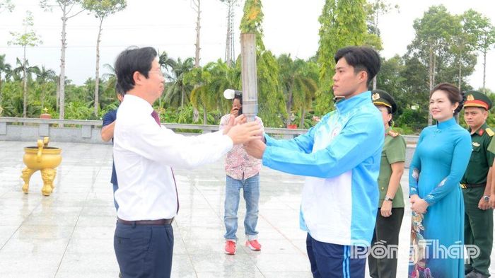Đồng chí Huỳnh Minh Tuấn trao ngọn đuốc truyền thống cho vận động viên Phạm Minh Bảo Kha.