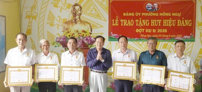 Đồng chí Phan Văn Hợp, Ủy viên Ban Thường vụ Tỉnh ủy, Bí thư Đảng ủy, Chủ tịch HĐND phường Hồng Ngự trao tặng Huy hiệu Đảng cho các đảng viên.