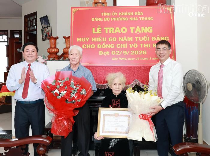 Đồng chí Lữ Thanh Hải và lãnh đạo phường Nha Trang tặng hoa chúc mừng đảng viên Võ Thị Rồi.