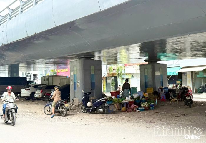 Tại gầm cầu nằm giữa 2 đường gom tầng mặt đất vẫn còn tình trạng người dân buôn bán trái cây, đậu xe ô tô, xe máy tràn lan.
