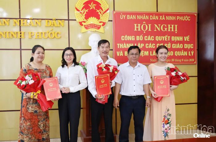 Lãnh đạo xã Ninh Phước trao quyết định và tặng hoa chúc mừng các hiệu trưởng.