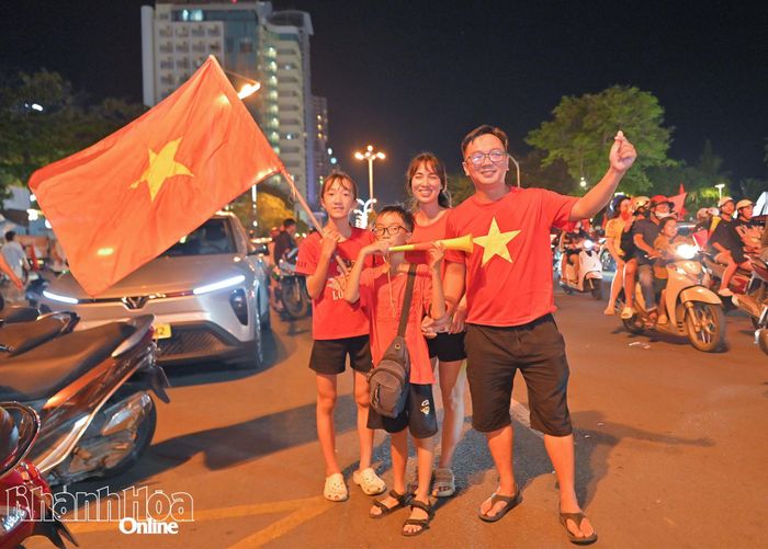 Một gia đình mặc áo cờ đỏ sao vàng hòa chung niềm vui chiến thắng của tuyển Việt Nam.