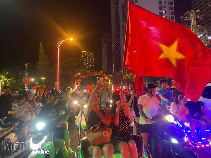 Các khách du lịch hòa trong dòng người mừng Việt Nam vô địch. Ảnh: VĂN GIANG