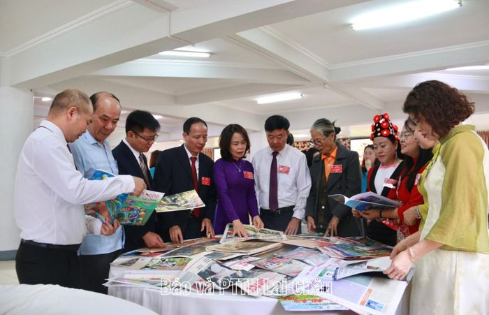 Các đại biểu tham quan, tìm hiểu các ấn phẩm báo chí được trưng bày bên lề phiên làm việc thứ nhất.