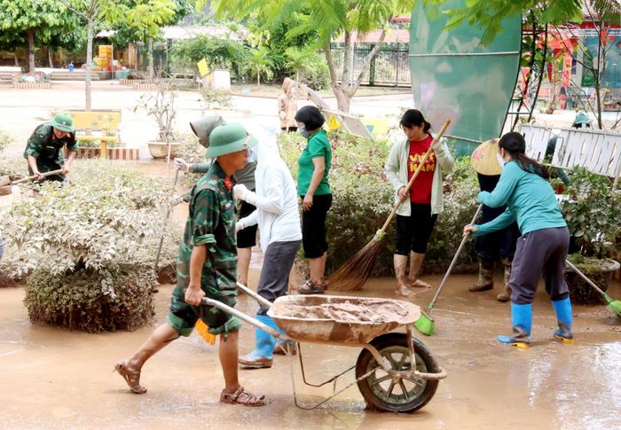 Nhân dân xã Na Sầm cùng với lực lượng quân đội thực hiện dọn bùn đất, rác thải