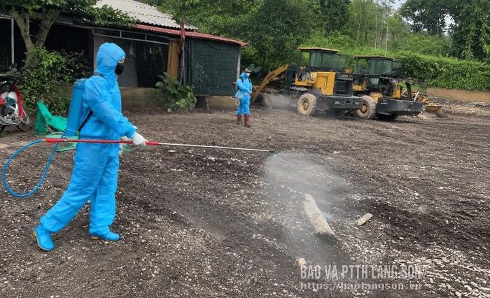 Cán bộ Trạm Y tế xã Kháng Chiến phun khử khuẩn tại nhà dân khu vực ngập úng