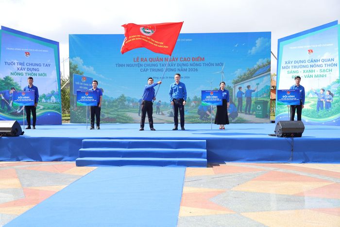 Anh Nguyễn Kim Quy, Bí thư Ban Chấp hành Trung ương Đoàn, Phó Chủ tịch Thường trực Trung ương Hội LHTN Việt Nam trao cờ xuất quân và chụp hình lưu niệm với các Đội hình trí thức trẻ tình nguyện chung tay xây dựng nông thôn mới