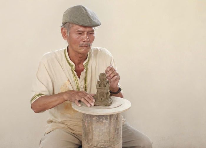 Nghệ nhân gốm Chăm tạo hình sản phẩm bằng tay