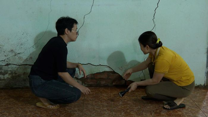 Phần tường ngăn giữa phòng khách và phòng ngủ của nhà chị Nguyễn Thị Dung bị nứt kéo dài. Chân tường bị gãy và đùn gạch ra ngoài (Ảnh: Xuân Trí)