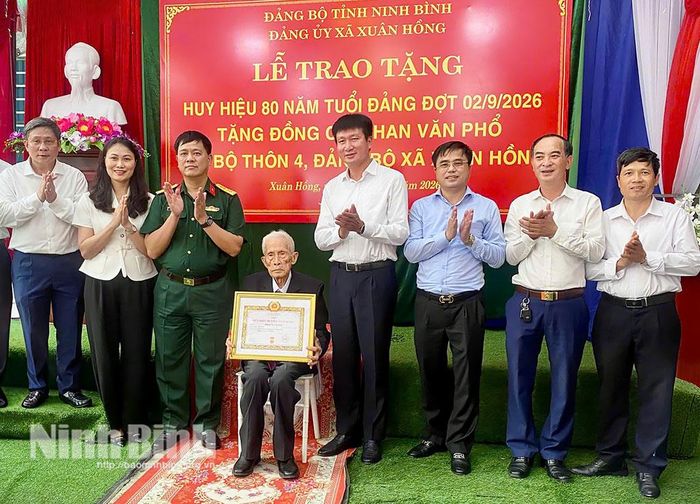 Các đại biểu chụp ảnh lưu niệm cùng đảng viên Phan Văn Phổ, Chi bộ thôn 4, Đảng bộ xã Xuân Hồng.