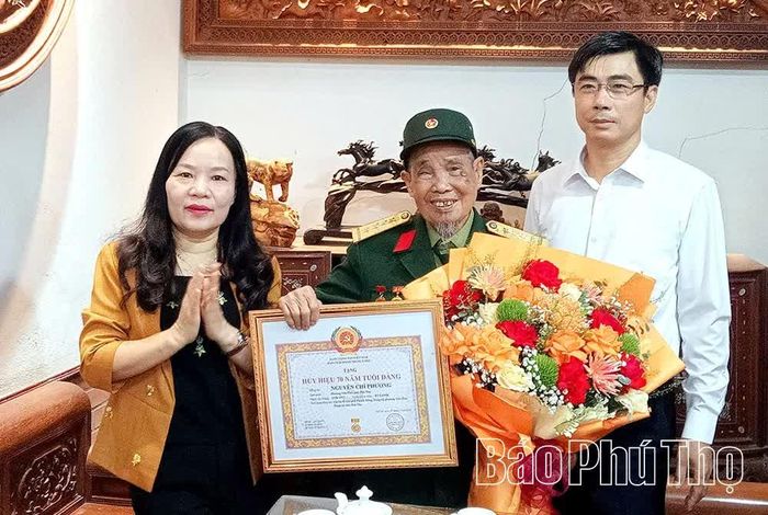 Phó Bí thư Thường trực Đảng ủy các cơ quan Đảng tỉnh Nguyễn Thị Thanh Huyền trao Huy hiệu 70 năm tuổi Đảng tặng đảng viên Nguyễn Chí Phương.