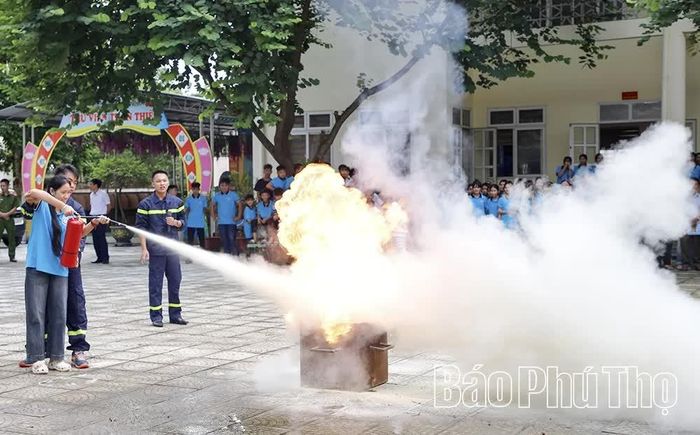 Học sinh Trường TH&THCS Dũng Phong, xã Mường Thàng thực hành kỹ năng sử dụng bình chữa cháy để dập tắt đám cháy.