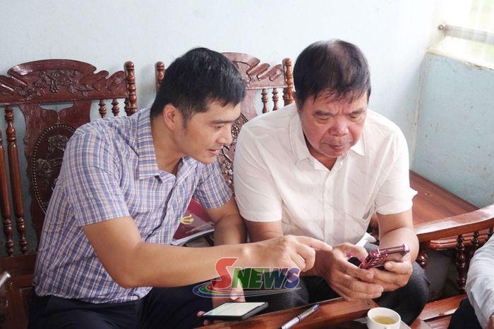 Cán bộ Ban Xây dựng Đảng Đảng ủy phường Chiềng An hướng dẫn đảng viên bản Phiêng Panh sử dụng Sổ tay đảng viên điện tử.