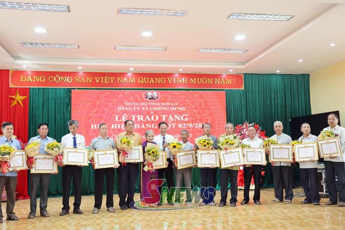 Đồng chí Bí thư Đảng uỷ xã Chiềng Mung trao Huy hiệu 50 năm, 45 năm tuổi Đảng cho các đảng viên.