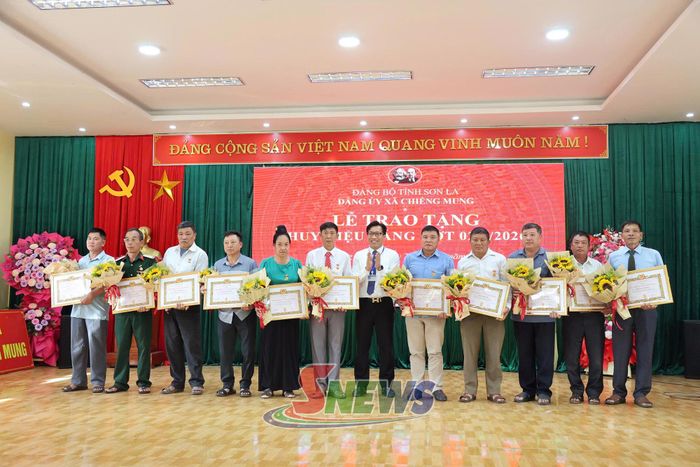 Phó Bí thư Đảng uỷ xã Chiềng Mung trao Huy hiệu 30 năm tuổi Đảng cho các đảng viên.