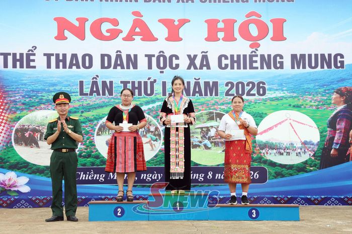 Ban tổ chức trao giải cho vận động viên nữ đoạt thành tích môn bắn nỏ.