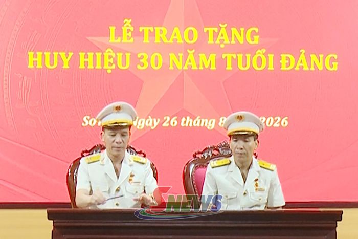 Đảng viên nhận Huy hiệu 30 năm tuổi Đảng thực hiện nghi thức ký Sổ tặng Huy hiệu Đảng của Đảng bộ.