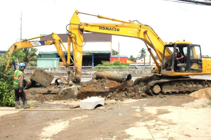 Xe cẩu đào các ống cống cũ để thay thế bằng cống thoát nước lớn hơn.