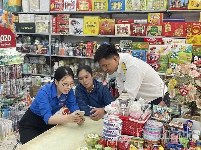 Công chức Thuế tỉnh Ninh Bình hỗ trợ hộ kinh doanh thực hiện thủ tục thuế trên ứng dụng eTax Mobile. Ảnh: TN