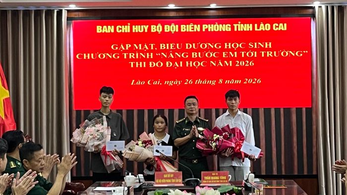 Đại tá Trần Quang Tùng, Chính ủy BĐBP tỉnh Lào Cai tặng hoa chúc mừng các cháu đỗ Đại học. Ảnh: Trung Dũng