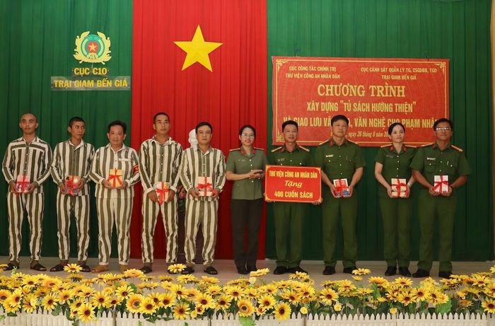 Trung tá Đỗ Thu Thơm, Giám đốc Thư viện CAND trao sách tặng Trại giam Bến Giá và các phạm nhân.