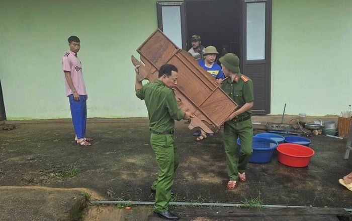 Lực lượng Công an hỗ trợ các hộ dân có nguy cơ bị sạt lở, lũ quét di dời đến nơi an toàn.