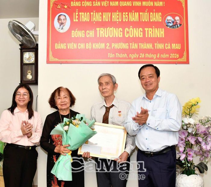 Phó Bí thư Thường trực Tỉnh uỷ Huỳnh Quốc Việt trao Huy hiệu 65 năm tuổi Đảng và tặng hoa chúc mừng đồng chí Trương Công Trình.
